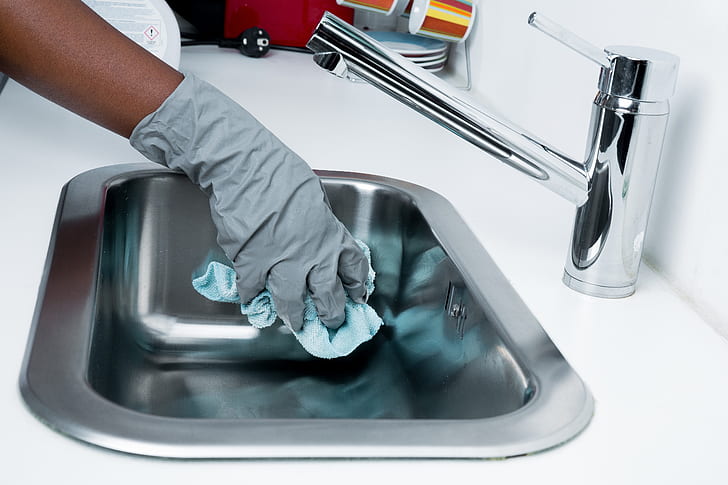 A house cleaner utilizing speed cleaning techniques to clean a kitchen sink