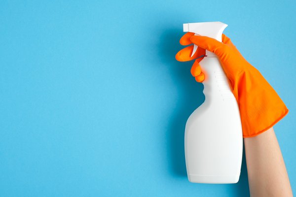 cleaning spray bottle with gloved hand