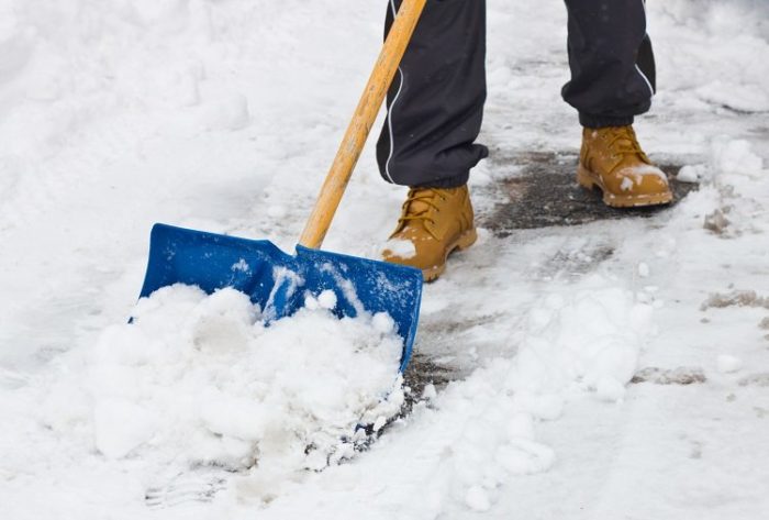 shoveling snow in a driveway