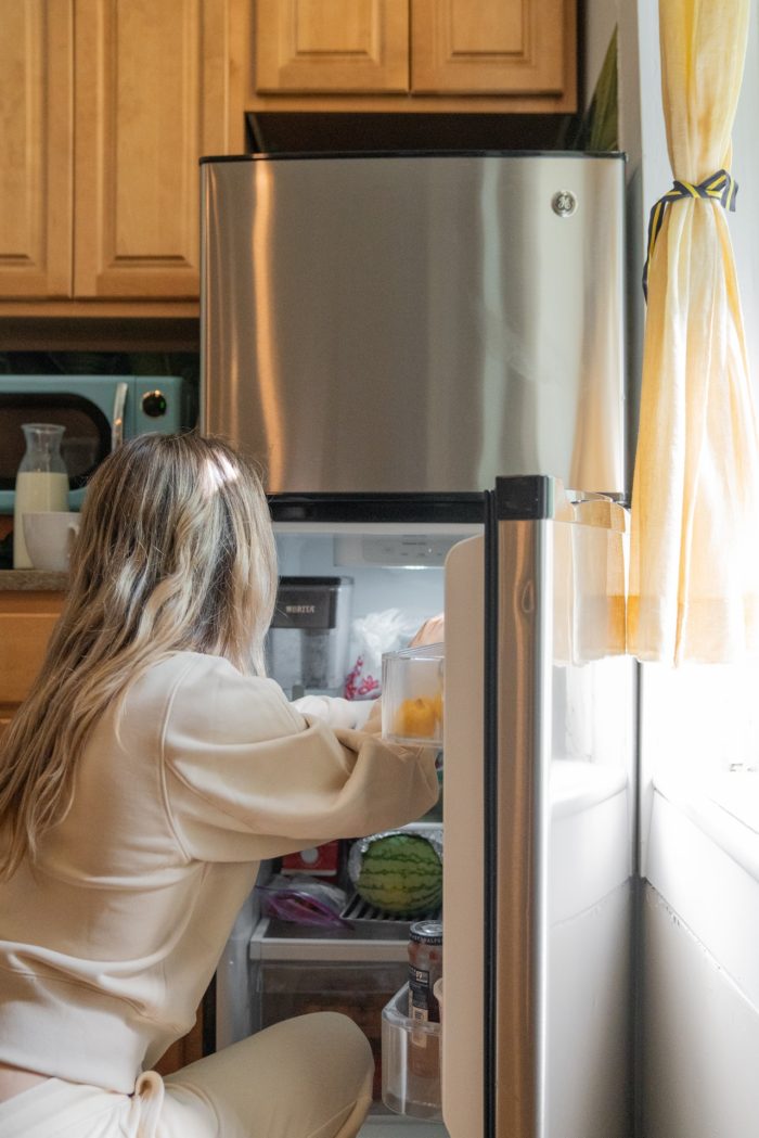 woman organizing her stainless steel refrigerator