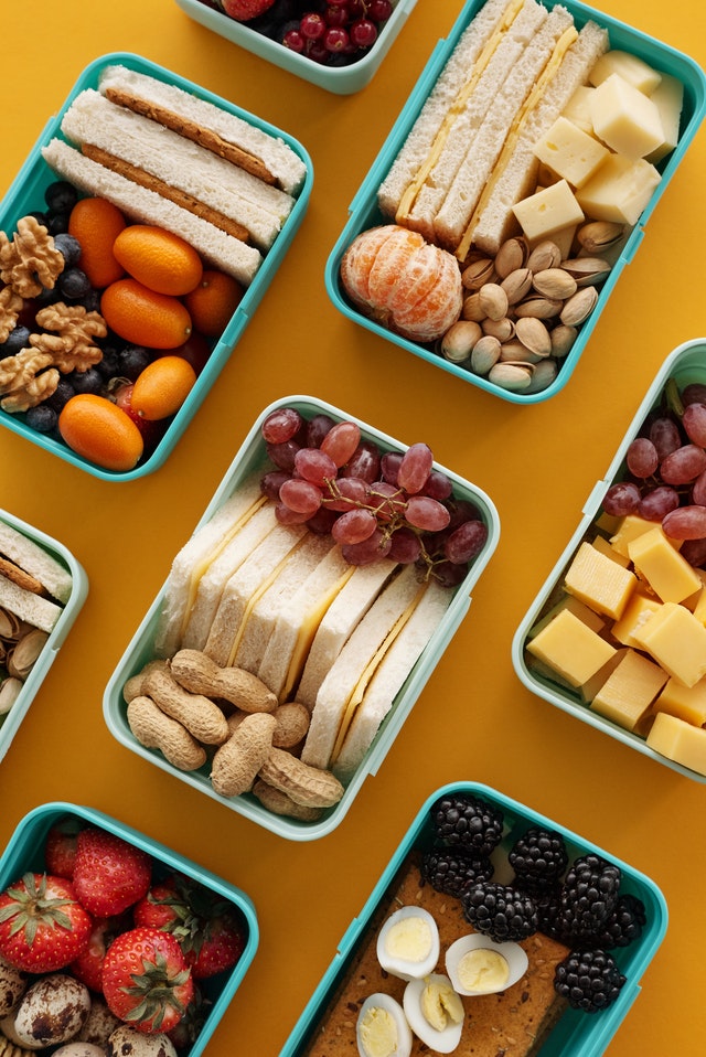 lunch boxes filled with various fruits and nuts