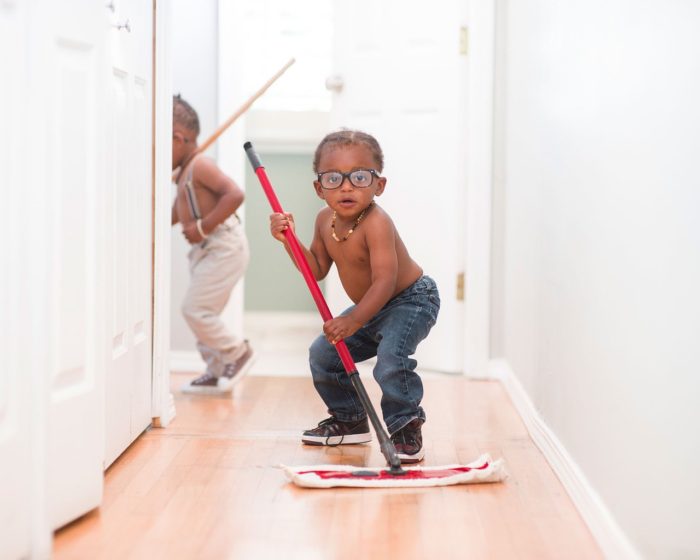 a kid mopping the floor of a hallway