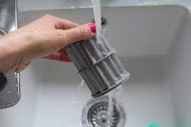 rinsing a dishwasher filter in a sink